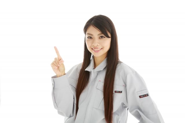 人差し指を立てる作業服の女性